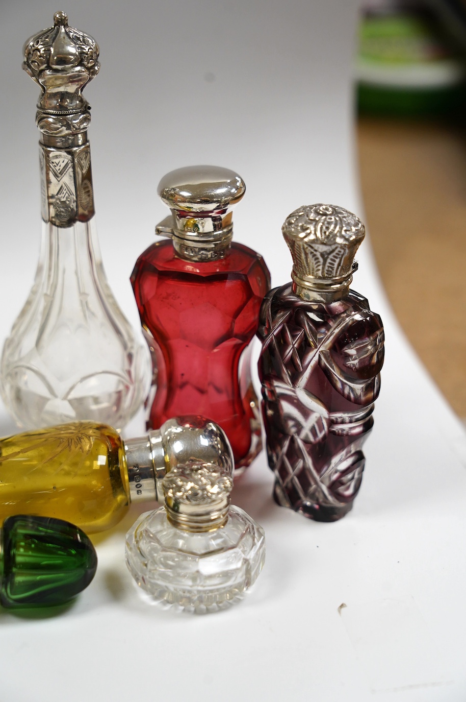 A collection of ten assorted Victorian and later silver or white metal mounted glass scent bottles, including teardrop shaped by Saunders & Shepherd, Birmingham, 1884, 12.7cm. Condition - poor to fair to good